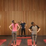 Men and women performing stretching exercises on mats in a fitness class